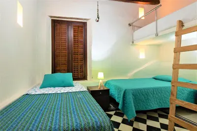 a bedroom with two beds and a ladder at Casa San Pedro - Exclusive 3BR Colonial Apt in Centro Historico by Huespedia in Cartagena de Indias