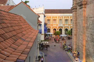 a city street with a group of people and horse drawn carriages at Casa San Pedro - Exclusive 3BR Colonial Apt in Centro Historico by Huespedia in Cartagena de Indias