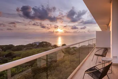 a balcony with two chairs and a view of the ocean at Santa Marta Marriott Resort Playa Dormida in Santa Marta