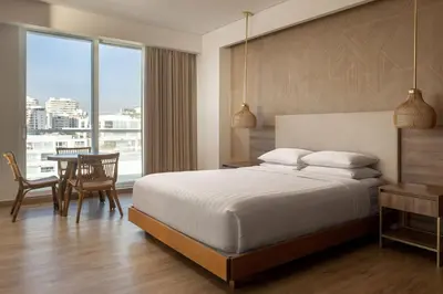 a bedroom with a large bed and a table and chairs at Santa Marta Marriott Resort Playa Dormida in Santa Marta