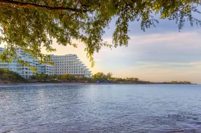 a large building on the shore of a body of water at Santa Marta Marriott Resort Playa Dormida in Santa Marta