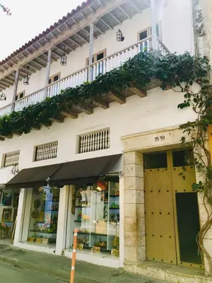 a white building with plants on the side of it at Calle de la iglesia 35-59 in Cartagena de Indias