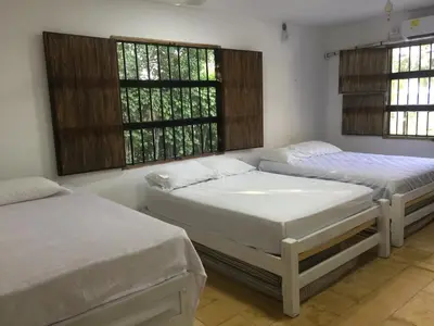 two beds in a room with two windows at Cabaña La Niña Cande-Punta Bolivar in San Antero