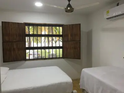 a bedroom with two beds and a window at Cabaña La Niña Cande-Punta Bolivar in San Antero