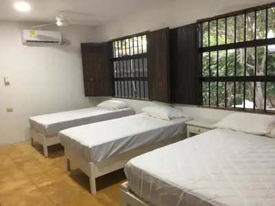 a room with three beds and two windows at Cabaña La Niña Cande-Punta Bolivar in San Antero