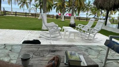 a group of white chairs and a table with a book at Cabaña La Niña Cande-Punta Bolivar in San Antero