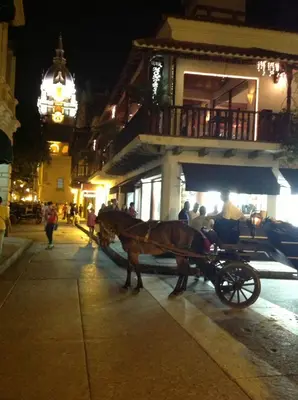 a horse drawn carriage on a city street at night at Alojamiento con Vista Y Salida al Mar in Cartagena de Indias
