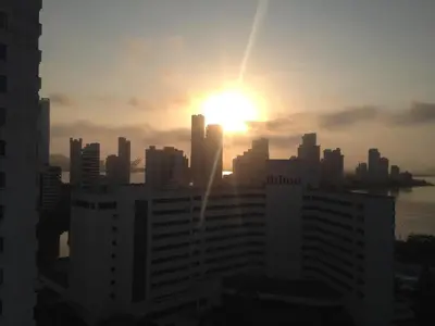 a city skyline with the sun setting behind buildings at Alojamiento con Vista Y Salida al Mar in Cartagena de Indias