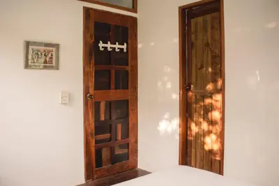 a room with a wooden door and a white wall at Casa Caracola in Tubará