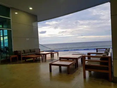 a room with tables and chairs and a view of the ocean at Encantador apartamento frente a la playa in Cartagena de Indias