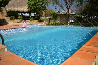 a woman standing next to a swimming pool at Casa en Santa Veronica Atlantico in Santa Veronica