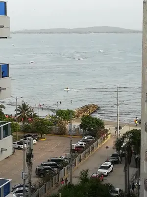 a parking lot next to a beach with cars parked at Ocean blue Ed Conquistador in Cartagena de Indias