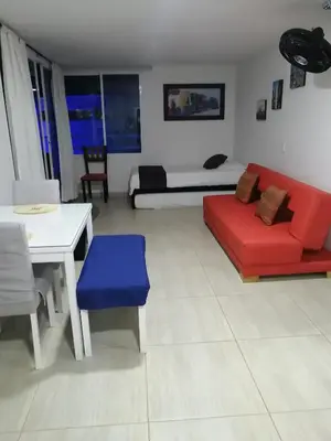 a living room with a red couch and a white table at Ocean blue Ed Conquistador in Cartagena de Indias