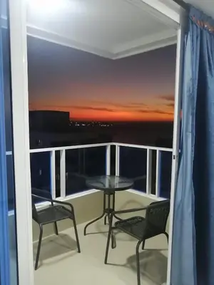 a balcony with a table and chairs and a sunset at Ocean blue Ed Conquistador in Cartagena de Indias
