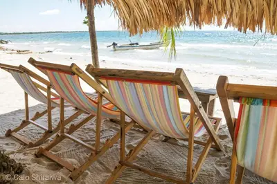 two chairs and a table on the beach at Canto de Caracola in Rincón
