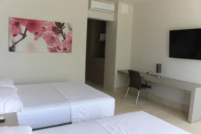 a bedroom with a bed and a desk with a television at Hotel Rilux Tolú -Casa Danae- in Tolú