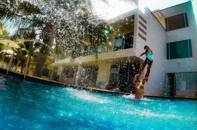 a woman standing in the water at a swimming pool at Hotel Rilux Tolú -Casa Danae- in Tolú