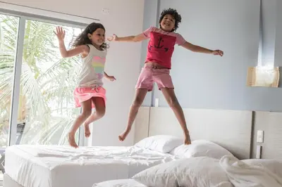 two children jumping on beds in a bedroom at Hotel Rilux Tolú -Casa Danae- in Tolú