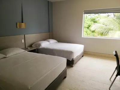 a hotel room with two beds and a window at Hotel Rilux Tolú -Casa Danae- in Tolú