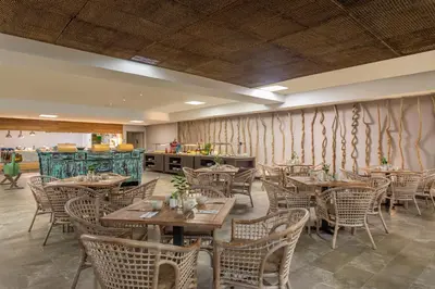 a restaurant with tables and chairs in a room at Grand Sirenis Cartagena in Cartagena de Indias