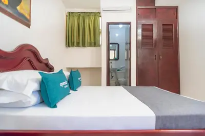 a bedroom with a bed with blue and white pillows at Ayenda 1309 Villa Dilia in Barranquilla