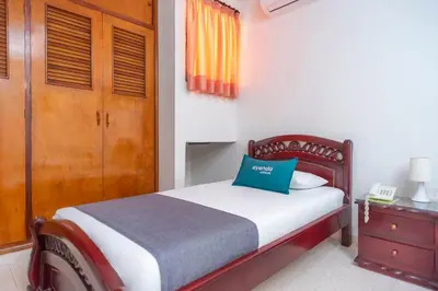 a bedroom with a bed with a blue pillow on it at Ayenda 1309 Villa Dilia in Barranquilla