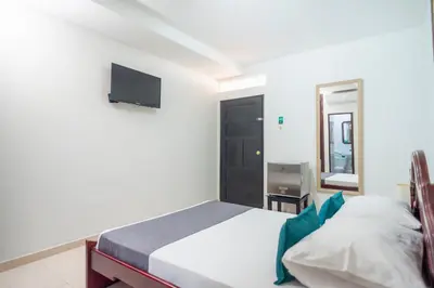 a bedroom with a bed and a tv on the wall at Ayenda 1309 Villa Dilia in Barranquilla