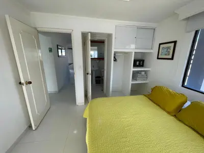 a white room with a bed and a yellow blanket at Vista Al Mar, Aire Acondicionado en Todo el Apto, Wi-Fi, Parqueadero in Cartagena de Indias