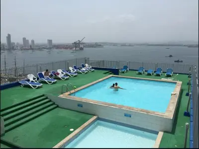 a person swimming in a swimming pool on top of a building at Vista Al Mar, Aire Acondicionado en Todo el Apto, Wi-Fi, Parqueadero in Cartagena de Indias