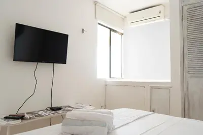 a bedroom with a flat screen tv on a white wall at Apt frente al Mar 10 min a pie Centro Histórico in Cartagena de Indias
