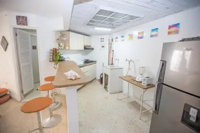 a kitchen with a refrigerator and a table in it at Apt frente al Mar 10 min a pie Centro Histórico in Cartagena de Indias