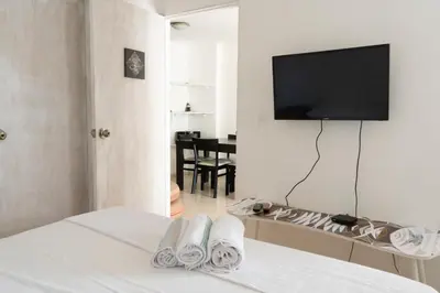 a bedroom with a bed with a tv on the wall at Apt frente al Mar 10 min a pie Centro Histórico in Cartagena de Indias