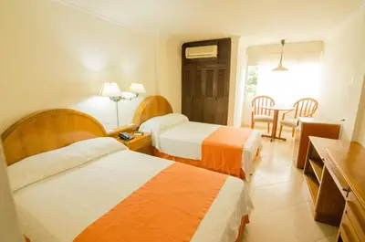 a hotel room with two beds and a table at Hotel Majestic in Barranquilla