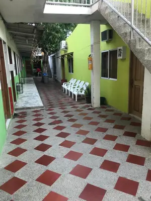 a corridor of a building with a red and white checkered floor at Cabaña La Fortaleza in Tolú