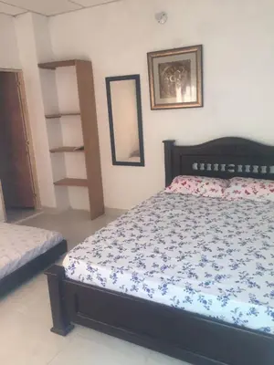 a bedroom with a bed with a blue and white comforter at Cabaña La Fortaleza in Tolú