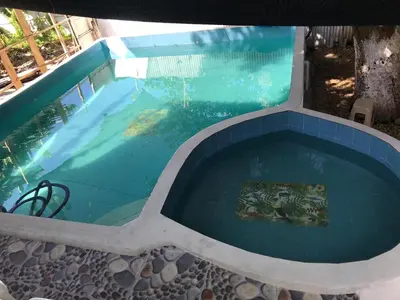 a large swimming pool with a blue tiled at Cabaña La Fortaleza in Tolú
