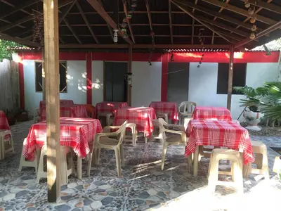 a group of tables and chairs with red checkered table cloth at Cabaña La Fortaleza in Tolú