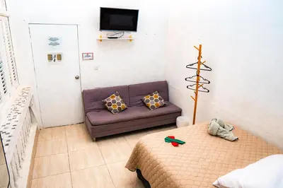 a living room with a couch and a tv at Hostal Badillo SV in Cartagena de Indias