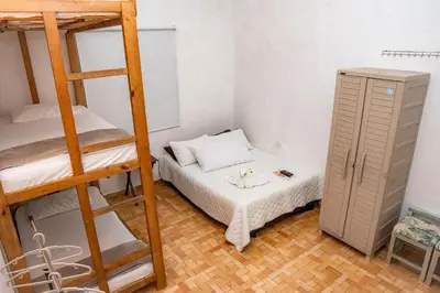 a small room with a bunk bed and a small cabinet at Hostal Badillo SV in Cartagena de Indias