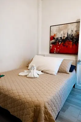 a bed in a room with a painting on the wall at Hostal Badillo SV in Cartagena de Indias
