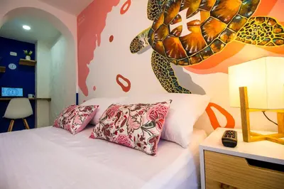 a bedroom with a bed and a turtle mural on the wall at Casa del Puerto Hostel & Suites in Cartagena de Indias