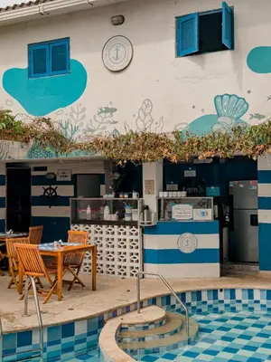 a restaurant with a table and chairs next to a pool at Casa del Puerto Hostel & Suites in Cartagena de Indias