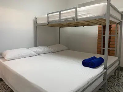 two bunk beds in a room with a blue pillow at Casa de la Cruz Centro Historico in Cartagena de Indias