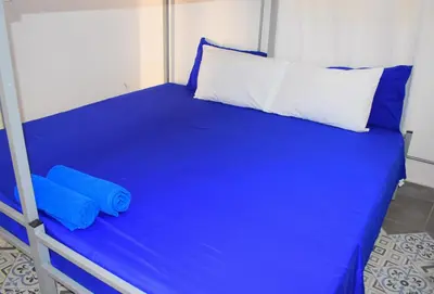 a bed with blue sheets and two pillows on it at Casa de la Cruz Centro Historico in Cartagena de Indias