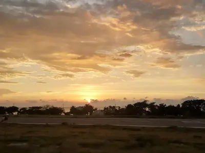 an empty road with a sunset in the background at VILLA MORELI in Papare