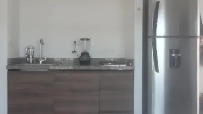 a kitchen with a stainless steel refrigerator and wooden cabinets at VILLA MORELI in Papare
