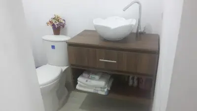 a bathroom with a white toilet and a sink at VILLA MORELI in Papare