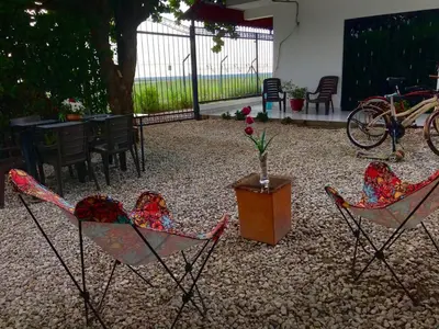 two chairs and a table with a vase of flowers at VILLA MORELI in Papare