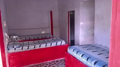 two beds in a room with red and white at MAR SERENO Recinto Natural Casa Museo MERY LORA de CIFUENTES Condominio de Cabañas frente al MAR in Coveñas