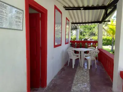 a table and chairs on the porch of a house at MAR SERENO Recinto Natural Casa Museo MERY LORA de CIFUENTES Condominio de Cabañas frente al MAR in Coveñas